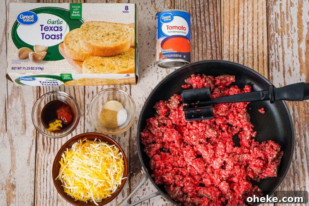 Garlic Bread Sloppy Joes: Cheesy Savory Sandwich Recipe 5 A box of Garlic Texas Toast, Condensed Tomato soup, Worcestershire sauce, yellow mustard, and ketchup, onion powder, salt, and garlic powder, shredded colby jack cheese, and broken up raw ground beef sitting in a medium black skillet.
