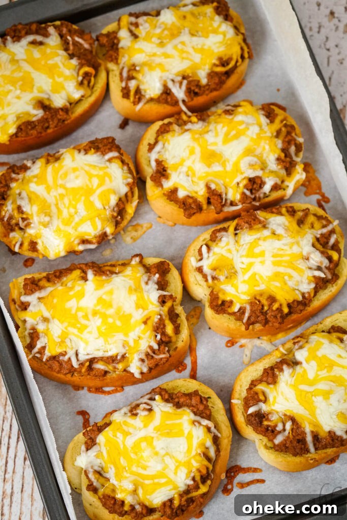 Garlic Bread Sloppy Joes: Cheesy Savory Sandwich Recipe 9 A baking tray of finished Garlic Bread Sloppy Joes topped with melted colby jack cheese.
