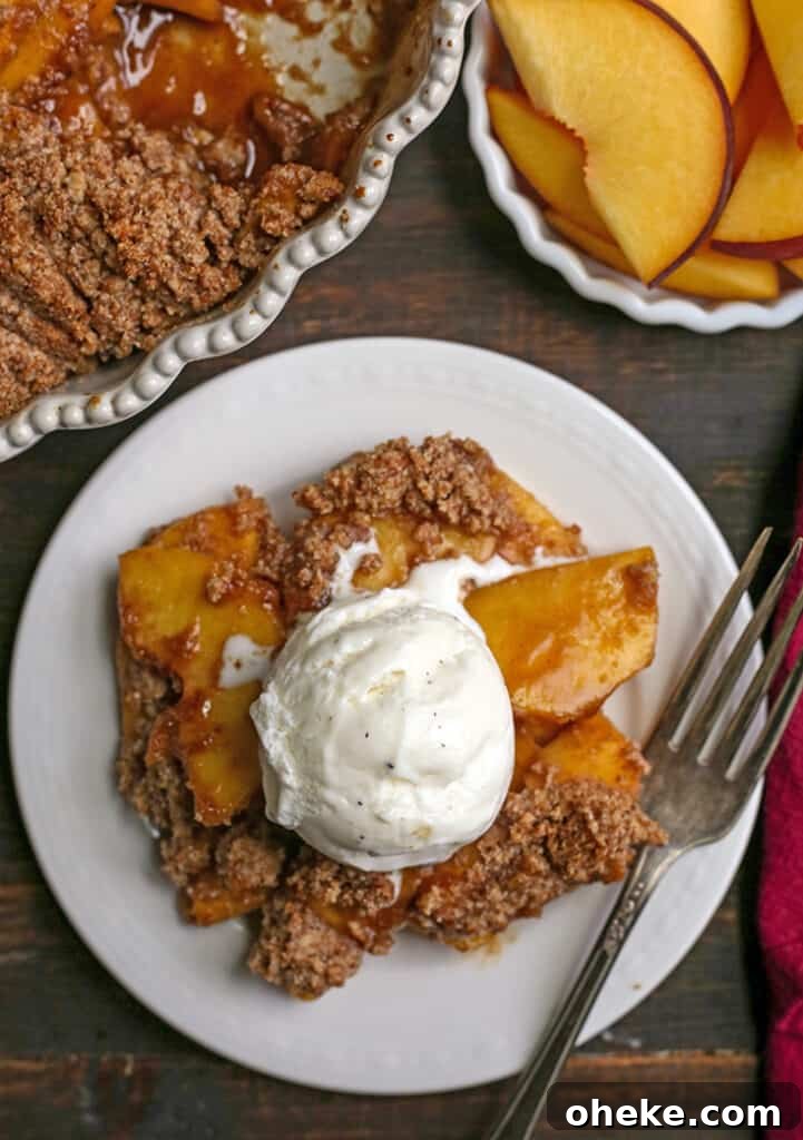 Paleo-Friendly Vegan Peach Crisp Recipe for Summer Desserts 3 vegan paleo peach crisp on a plate with ice cream on top