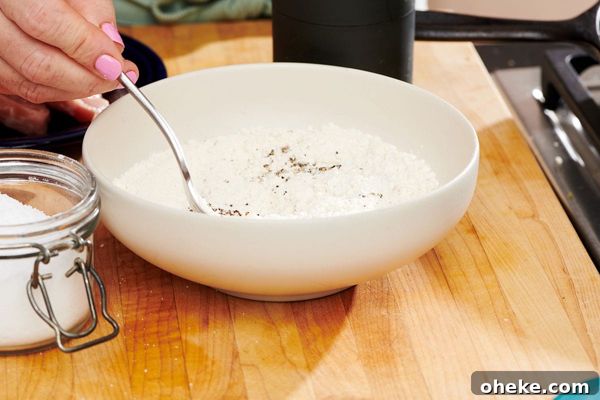 How to Flour Chicken Cutlets for Perfect Crispy Coating 5 Mixing herbs and spices into flour in bowl.