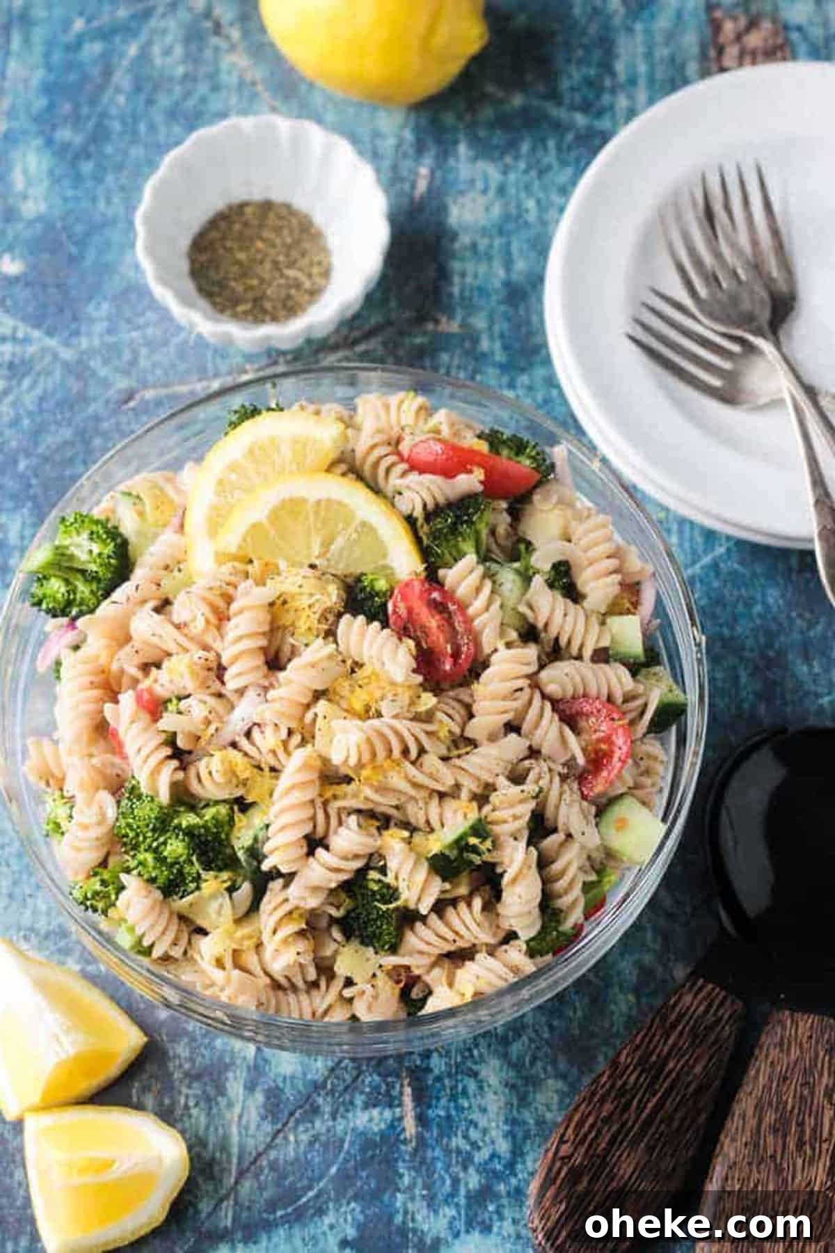 Zesty Lemon & Artichoke Pasta Salad Recipe for Summer 2 Bowl of vegan pasta salad with rotini noodles, broccoli, cucumber, artichokes, and tomatoes.