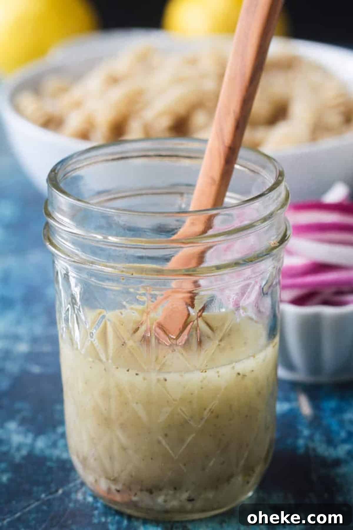 Zesty Lemon & Artichoke Pasta Salad Recipe for Summer 5 Small wooden spoon in a jar of lemon vinaigrette.