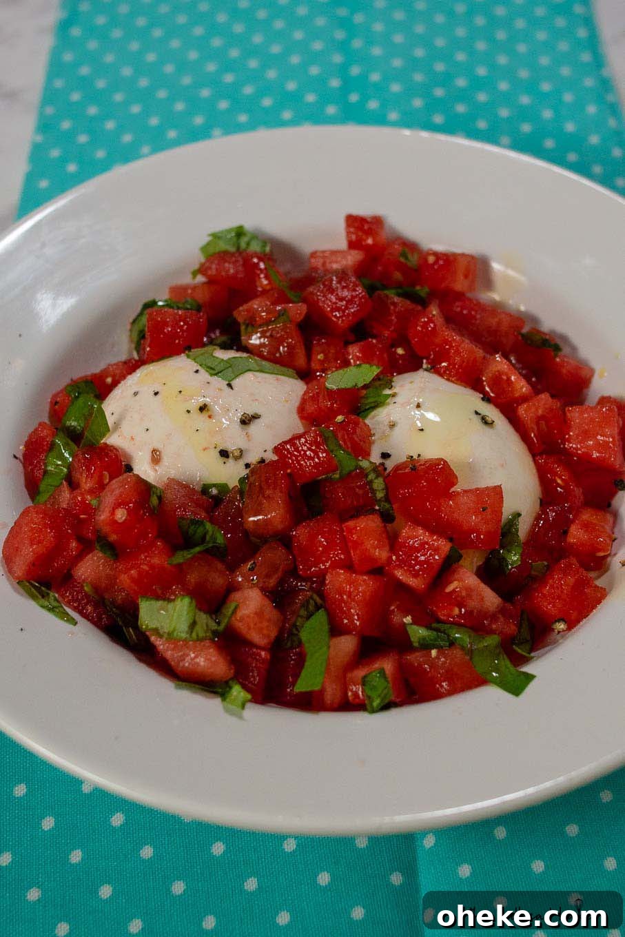 Refreshing Watermelon and Burrata Salad with Basil and Balsamic 2 A dish of watermelon burrata salad on a blue towel