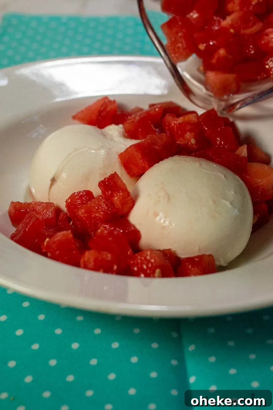 Refreshing Watermelon and Burrata Salad with Basil and Balsamic 3 Watermelon being poured into a dish with two balls of burrata