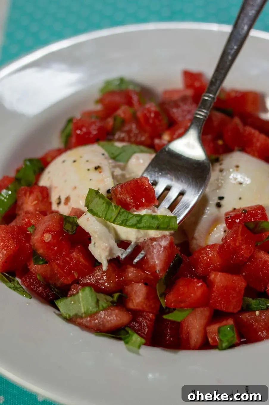 Refreshing Watermelon and Burrata Salad with Basil and Balsamic 4 A dish of watermelon burrata salad with a fork