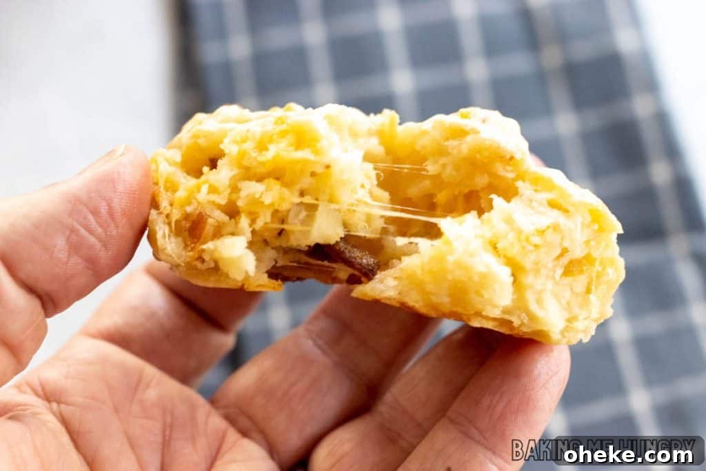 Savory Cheese & Bacon Breakfast Muffins That Impress 11 hand holding one of the cheese and bacon muffins