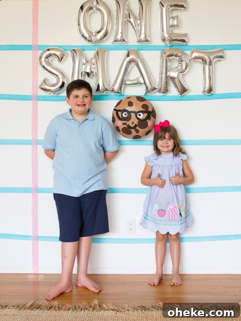Smart Cookie Back-to-School Party Ideas for Kids 2 kids in front of note pad backdrop