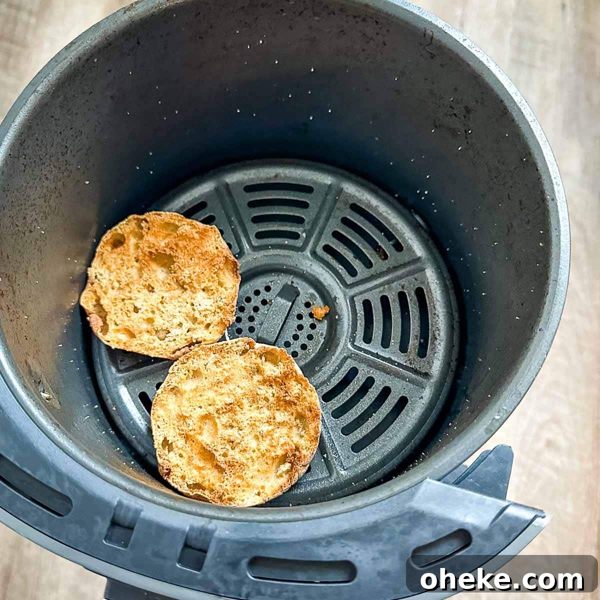 Air fried English muffins in air fryer basket.