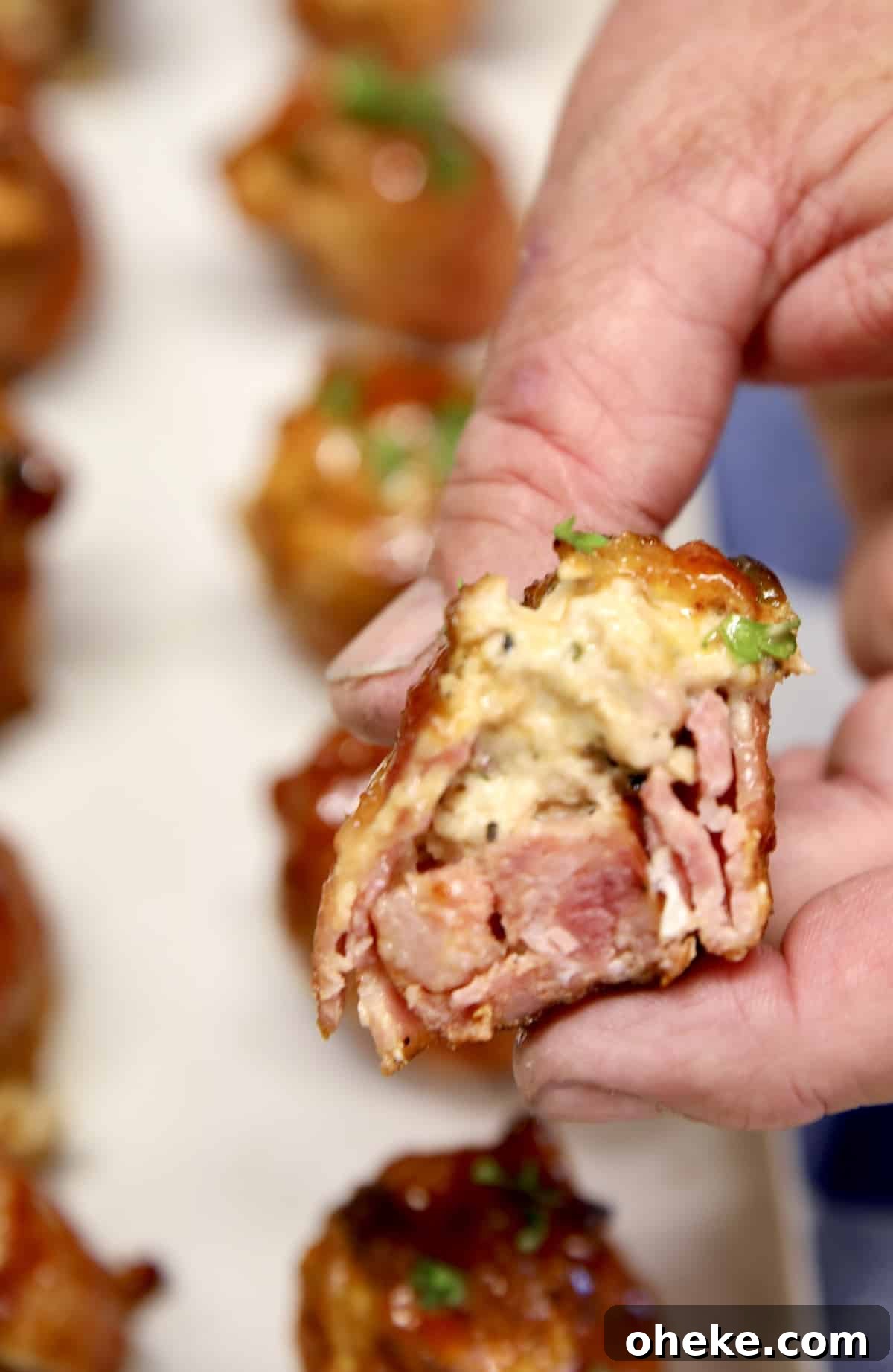 Hand holding half of a chicken popper pig shot.