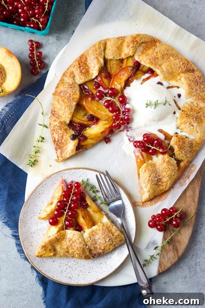 Perfect Peach Galette Recipe: Rustic Summer Tart with Almond Crust 6 Rustic peach galette with homemade buttery crust. A slice of peach galette on a plate. Fresh currants on top and vanilla ice cream