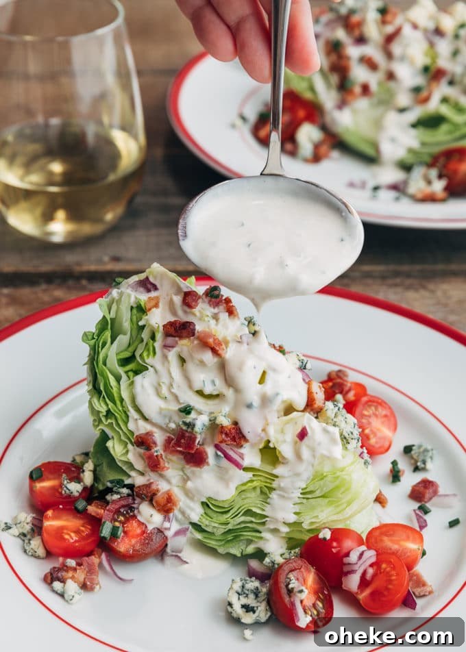 ladleful of blue cheese dressing pouring onto a loaded wedge salad