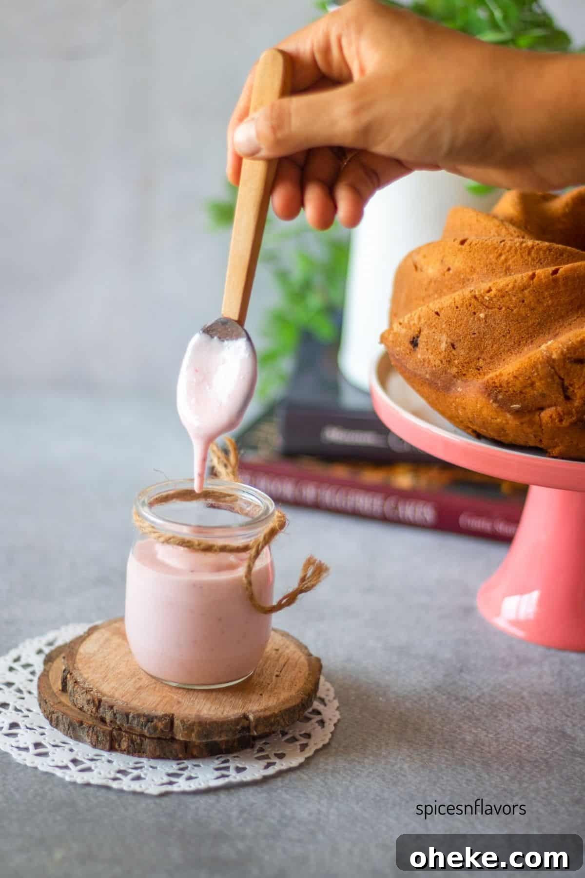 Fresh Strawberry Glaze for Cakes — Quick Homemade Icing 2 transferring strawberry glaze into a container using wooden spoon