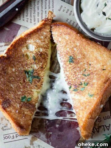 Overhead of a brioche grilled cheese cut in half on a wood surface.