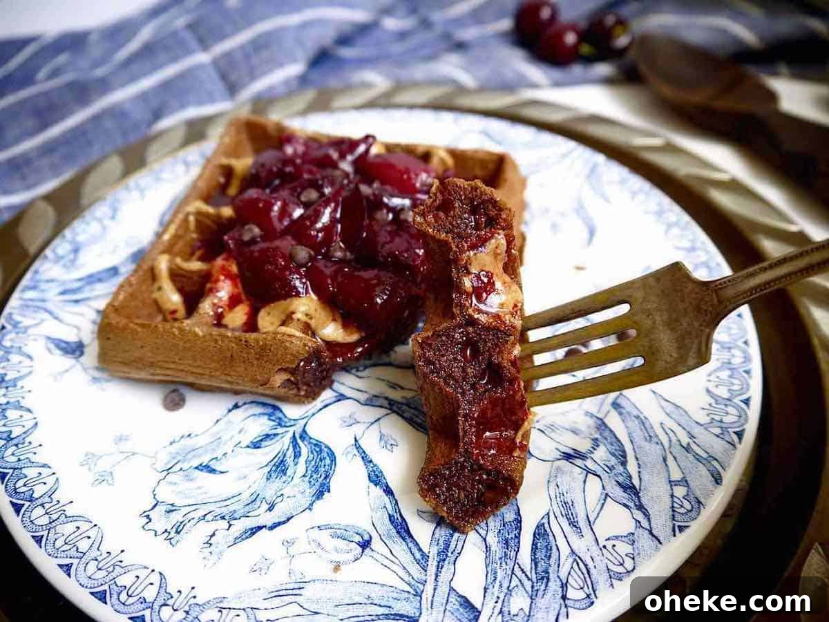Gluten-Free Chocolate Cherry Waffles — Paleo Recipe 7 A bite of a chocolate cherry waffle on a fork.