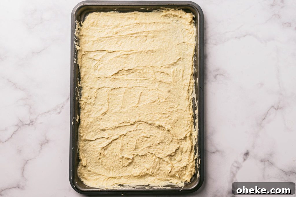 Bakery-Style Baked Apple Slices with Cinnamon Crumble 8 crust batter spread on a baking sheet