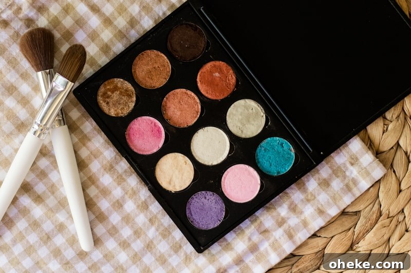 How to Make Natural Homemade Eyeshadow at Home 6 Eyeshadow on white and tan checker towel with white brushes by it.