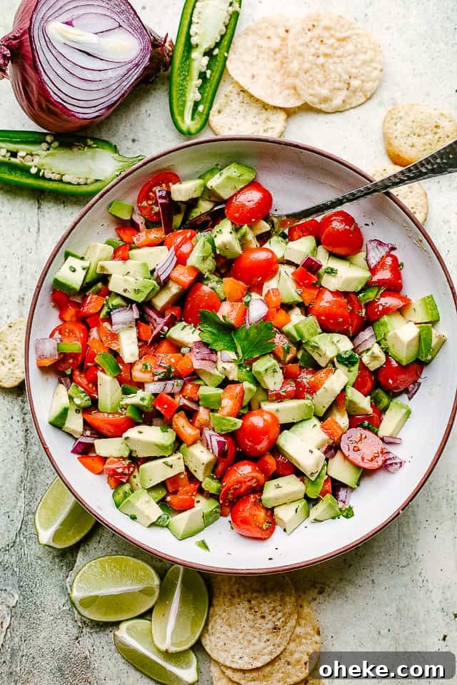 This avocado salsa is a next-level Cinco de Mayo recipe! It's creamy, chunky, and 100% addictive. It's like a flavor party in one bowl! Bowl of homemade avocado salsa with tortilla chips