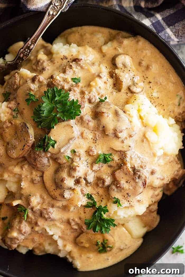 Creamy Ground Beef Stroganoff Recipe for Weeknight Dinners 4 overhead closeup: saucy beef stroganoff with hamburger over mashed potatoes