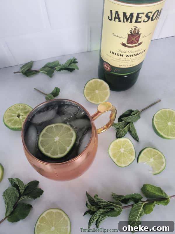 Irish Mule Cocktail & Mocktail Recipe with Video Guide 5 Irish Mule in a Copper Mug next to a bottle of Jameson Whisky and lime wheels and mint sprigs