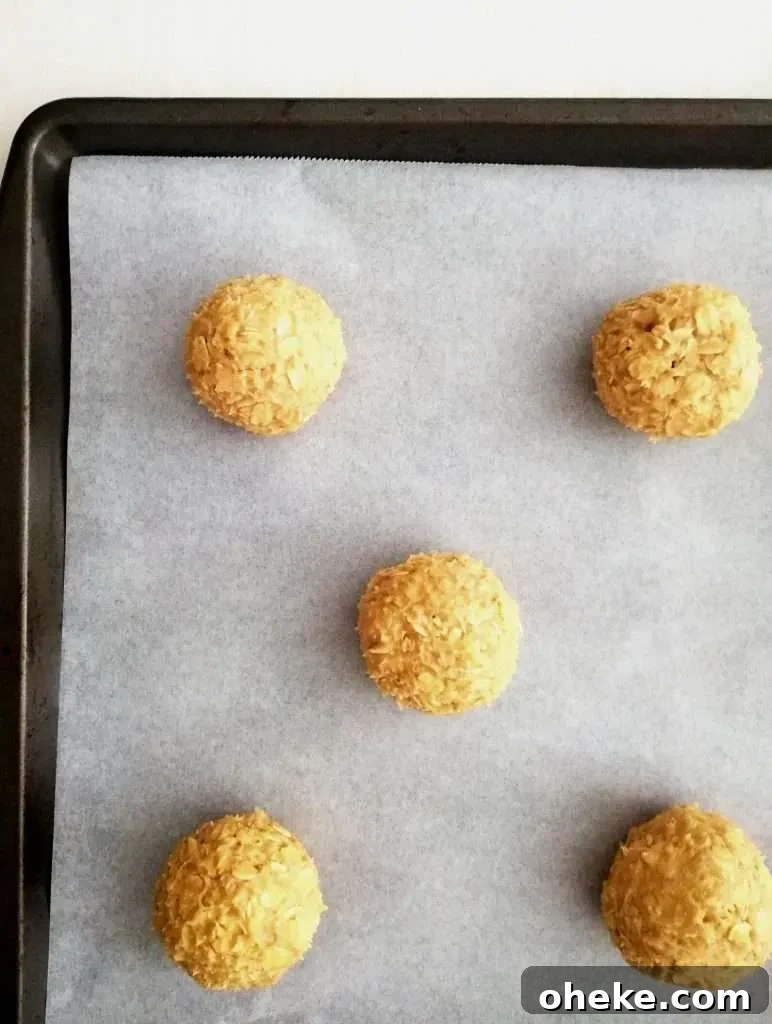 oatmeal cookie dough balls on parchment lined baking sheet overhead image