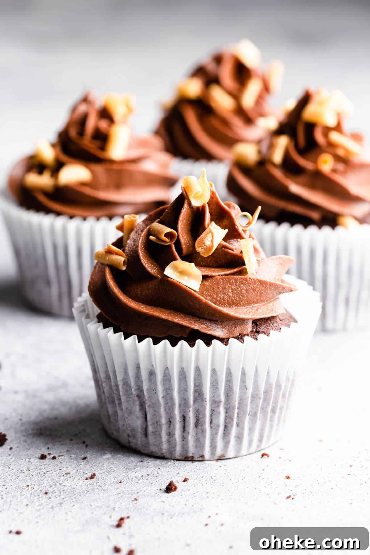 straight ahead angle close up of cupcakes with buttercream and chocolate curls on top