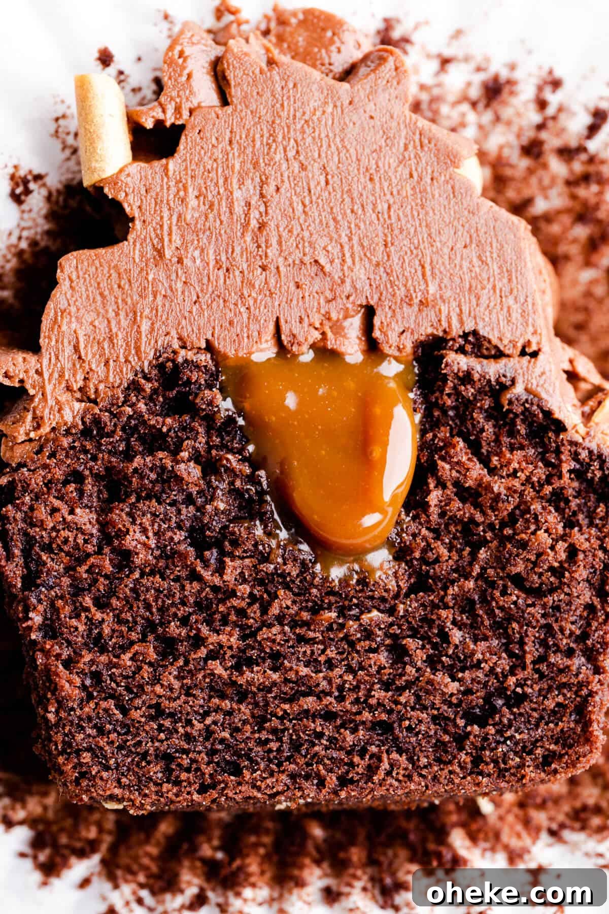 super close up of chocolate cupcake sliced in half with filling in the middle