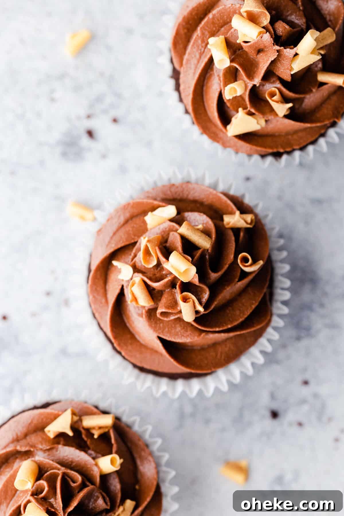 overhead shot of 3 chocolate cupcakes topped with chocolate buttercream
