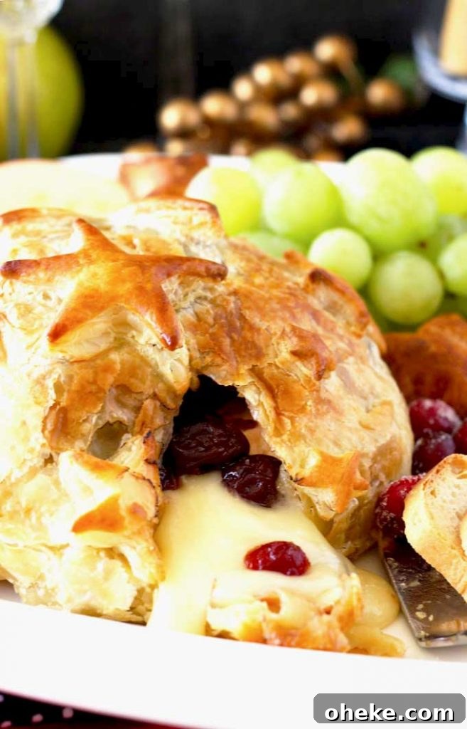 Baked Brie en Croûte with Cranberries and Puff Pastry 6 Close up of warm brie cheese oozing from the pastry.