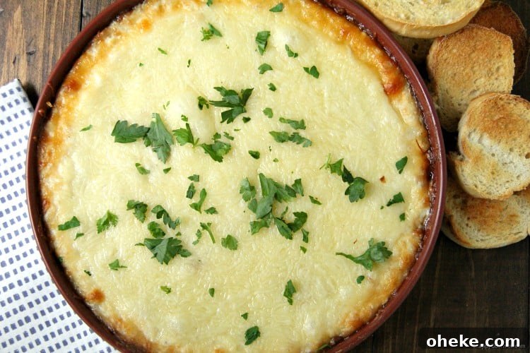 Simple Chicken Alfredo Dip, easy hot baked dip with chicken, cheese, and homemade alfredo sauce Chicken Alfredo Dip in baking dish and parsley