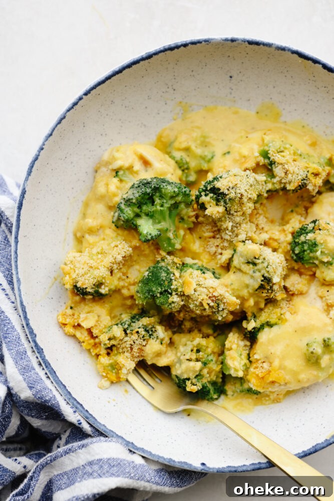 Comfort food at its finest, this broccoli cheddar chicken will fill you right up! Insanely delicious and straightforward to make, this is a dinner your entire family will go crazy over! Broccoli cheddar chicken cut up on a plate with a gold fork.