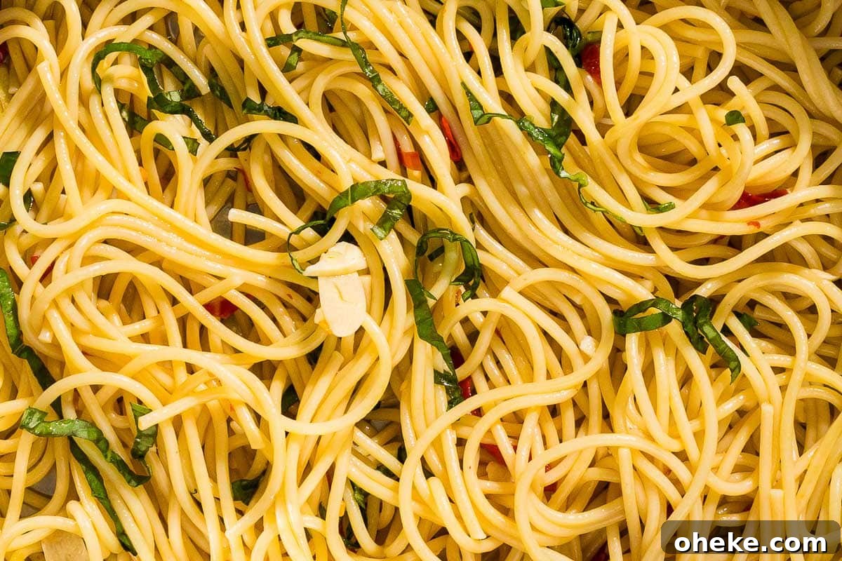 Perfect Pasta: Mastering Water, Salt and Timing 3 A close up of a bowl of spaghetti with garlic, chilis, and basil.