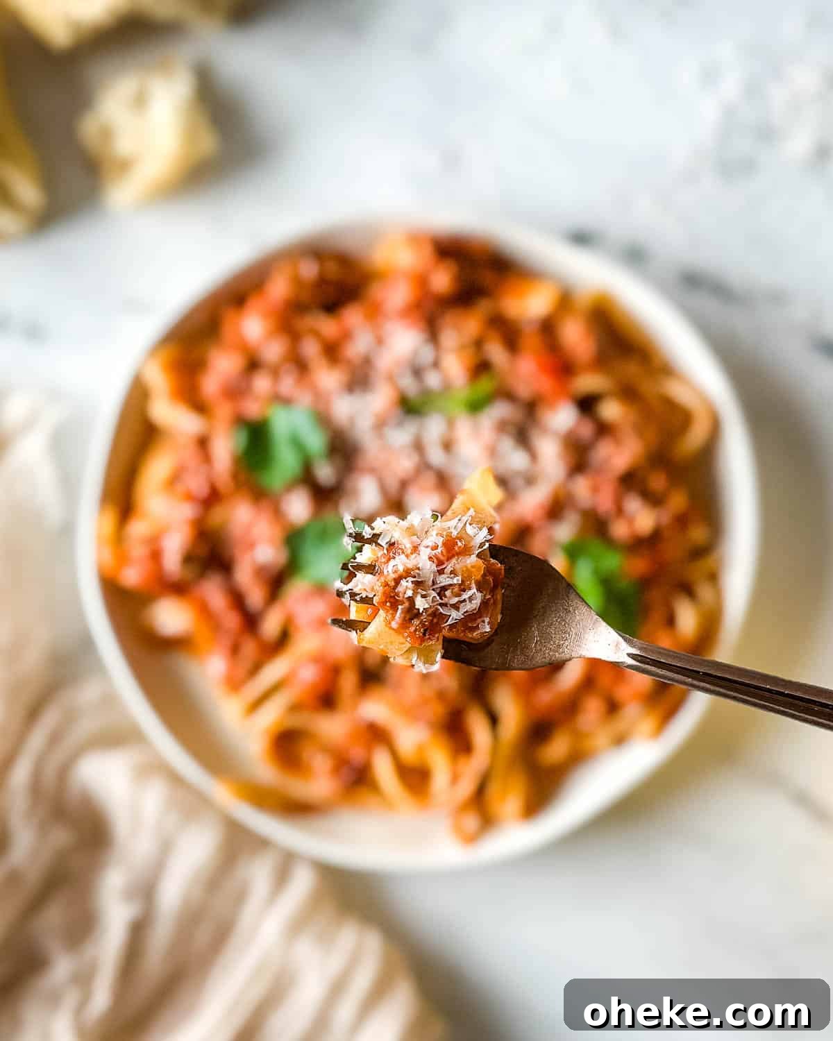 Perfect Pasta: Mastering Water, Salt and Timing 4 Closeup of pappardelle pasta twirled on a forked and coated with lamb ragu over a plate of slow cooker lamb ragu.