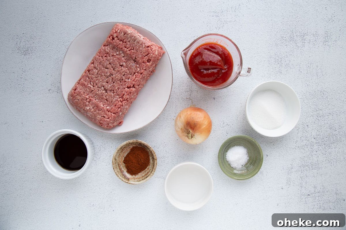 ground beef, ketchup, and small bowls of other ingredients on a white table.