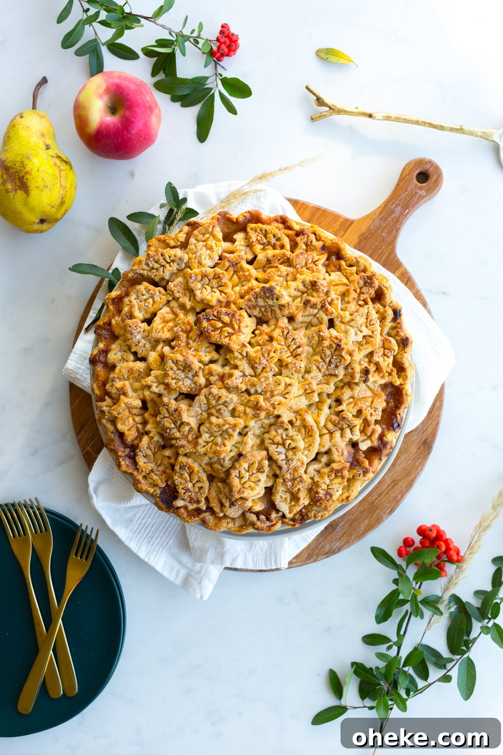 Apple Pear Gruyere Pie with leafy crust baked and cooling on a hot plate