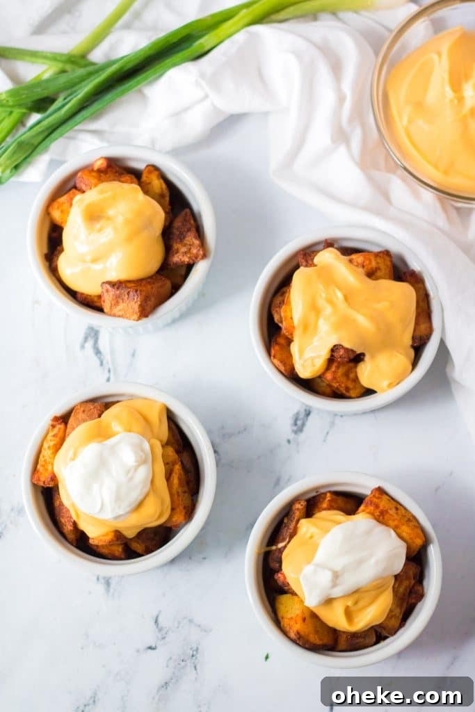 Air Fryer Cheesy Fiesta Potatoes — Taco Bell Copycat Recipe 7 cheesy fiesta potatoes served in four white ramekins