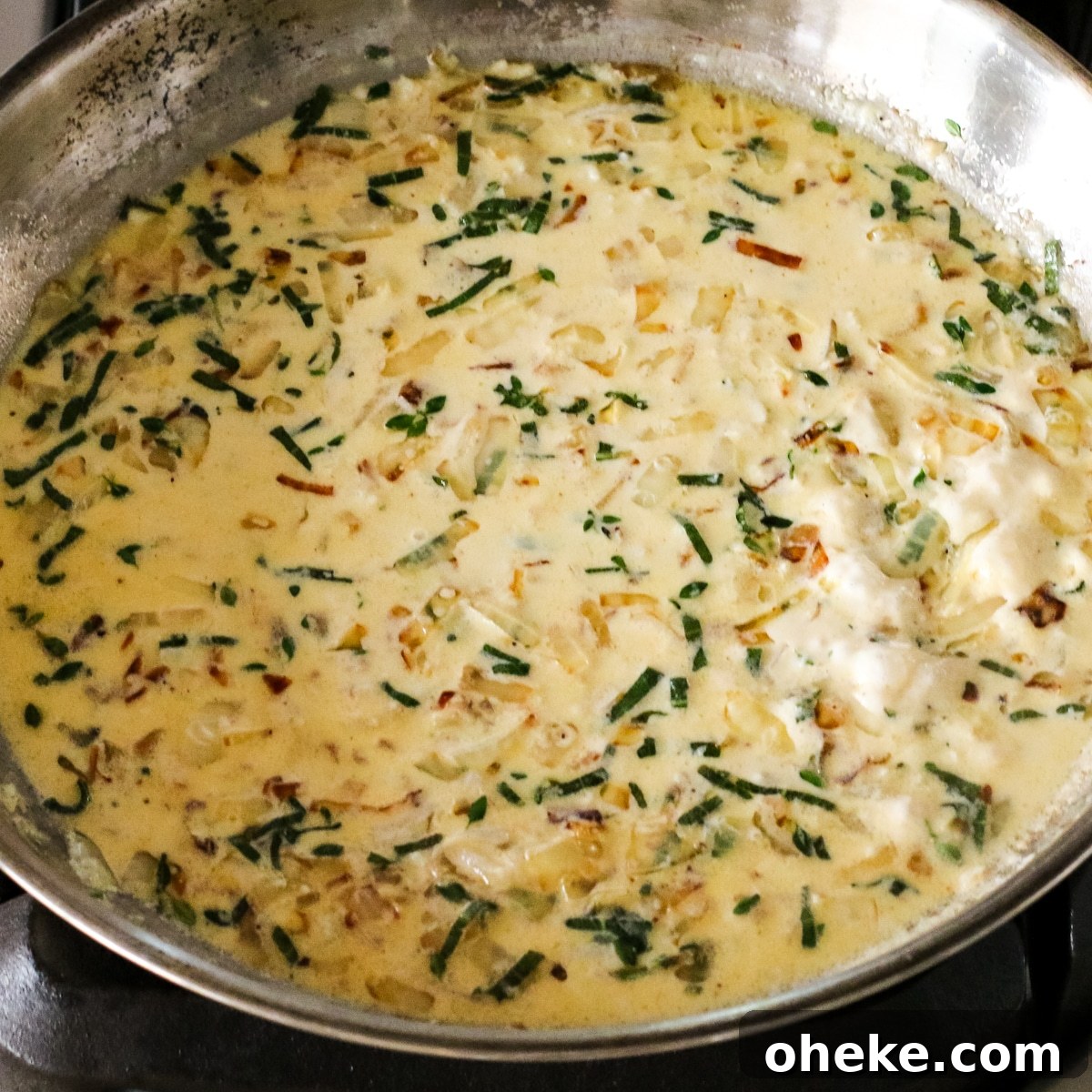 creamy carmalized onion sauce cooking in a pan.