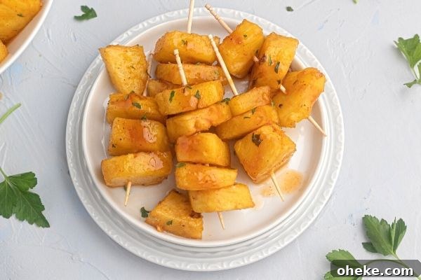 Juicy glazed pineapple served on a white plate. 