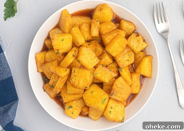 Juicy pineapple in honey and bbq juices, after being cooked in the air fryer. Served in a white bowl. 