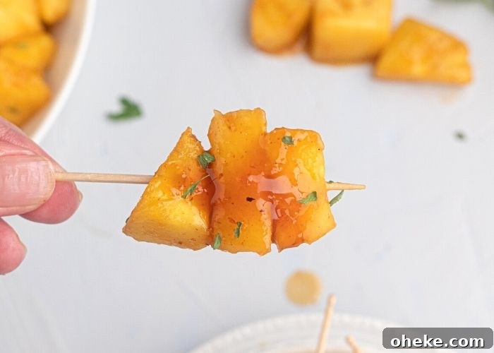Juicy glazed pineapple on a toothpick. 