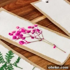 DIY Pressed Flower Bookmarks: Step-by-Step Craft Tutorial 10 Handmade pressed flower bookmark DIY, featuring pink flowers and green leaves on white paper with a brown paper border.