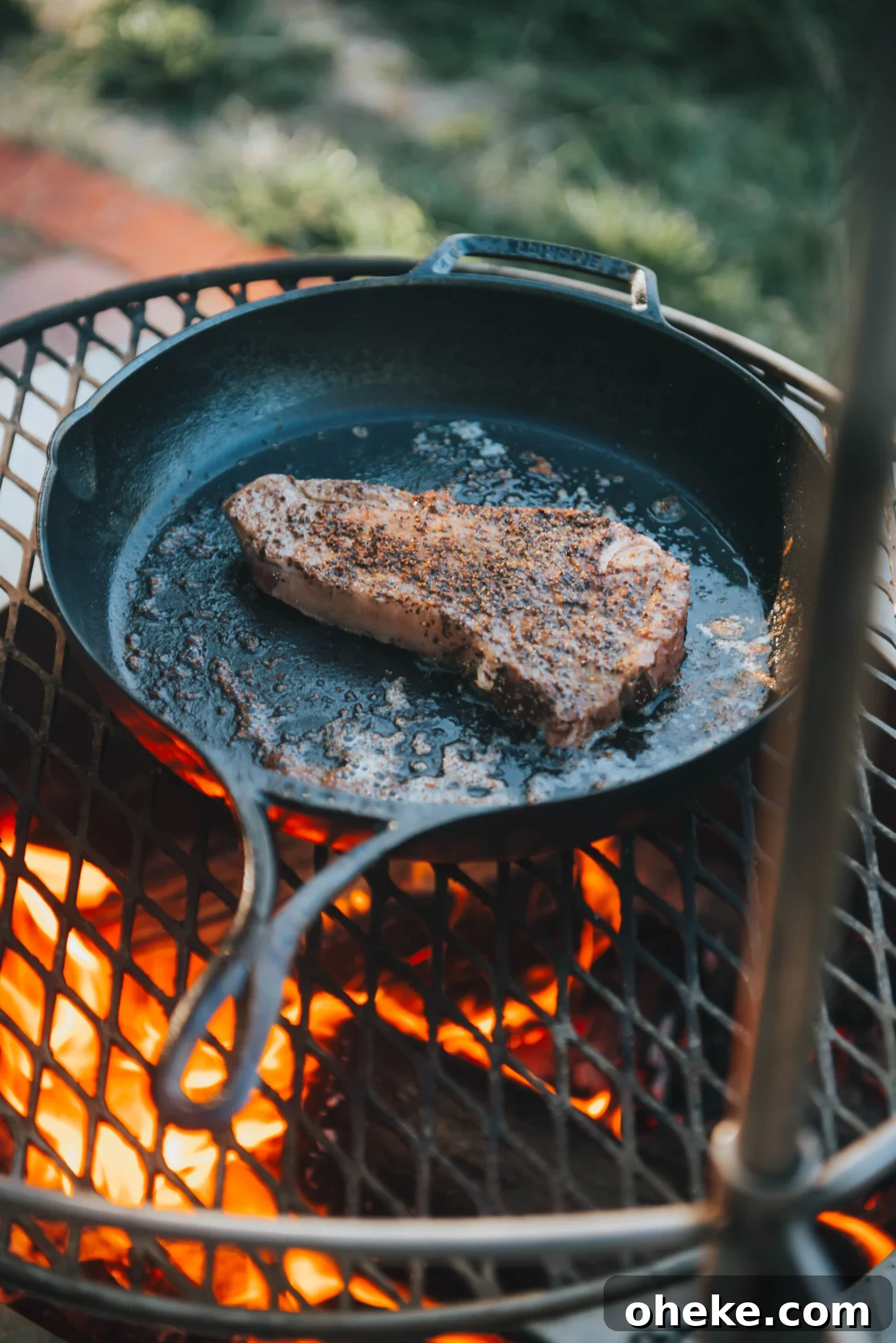 Strip steak in skillet over campfire.