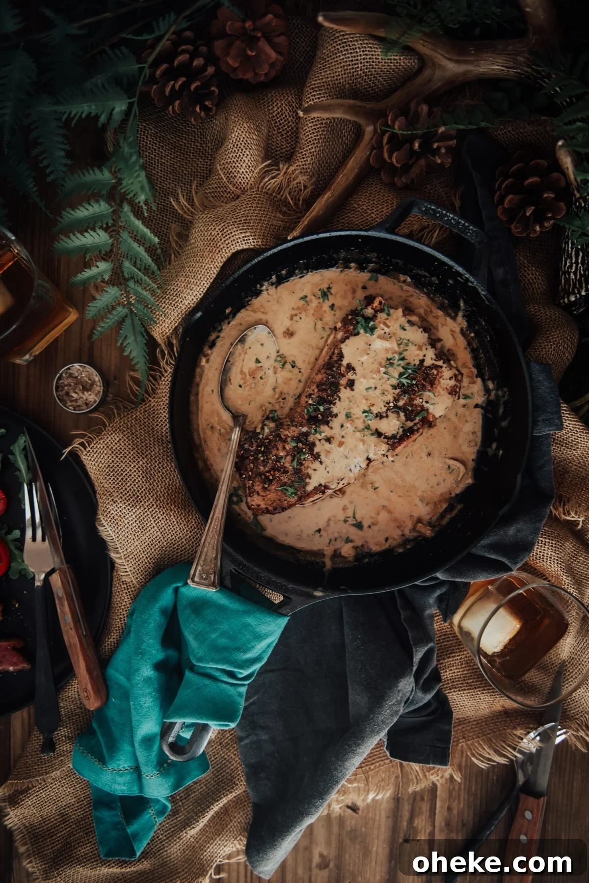 Overhead shot of steak in skillet smothered in sauce au poivre.