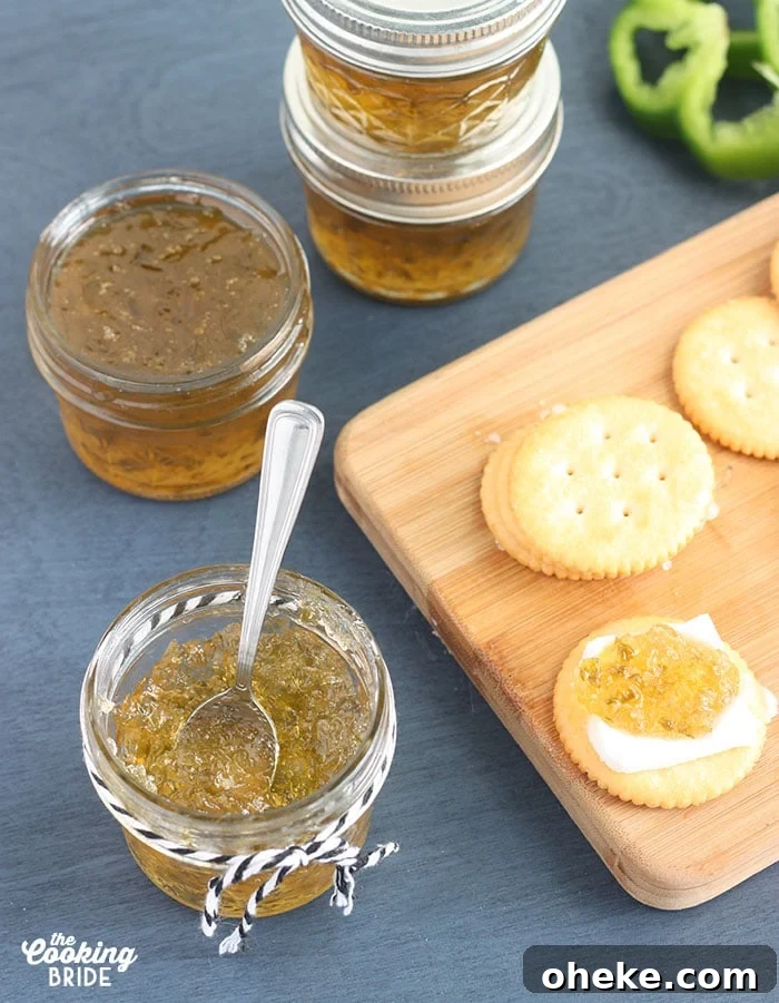 Sweet and Spicy Pepper Jelly Recipe for Preserving Peppers 5 small jelly jar of pepper jelly with crackers, fresh pepper slices and jelly jars in the background