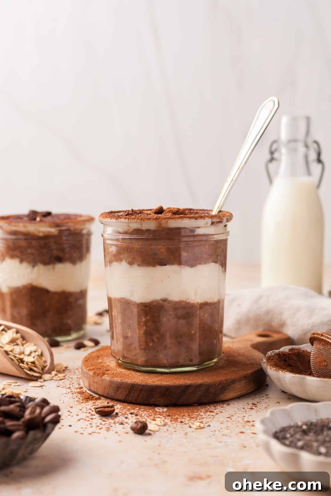 Based on the Italian coffee-infused dessert, these tiramisu overnight oats are a delicious, surprisingly nutritious way to start the day. A jar of tiramisu oats with a spoon in it.
