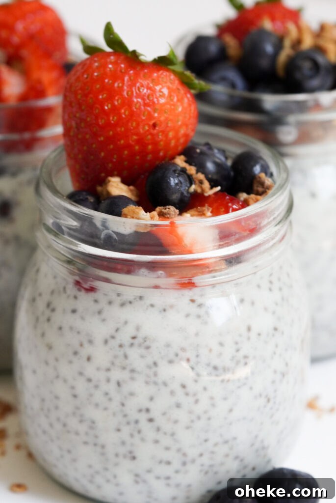 High-Protein Chia Pudding Recipe for Muscle Fuel 2 chia pudding protein jars on a white table with mixed berries.