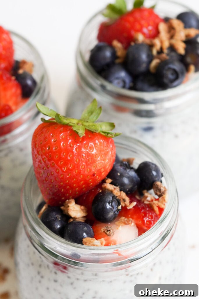 High-Protein Chia Pudding Recipe for Muscle Fuel 3 overhead shot of protein chia pudding jars with blueberries and strawberries.