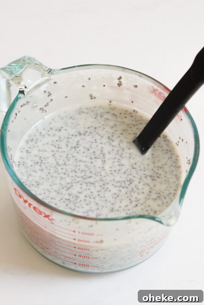 High-Protein Chia Pudding Recipe for Muscle Fuel 5 large glass pyrex measuring cup with the protein chia seed pudding and a large mixing spoon.
