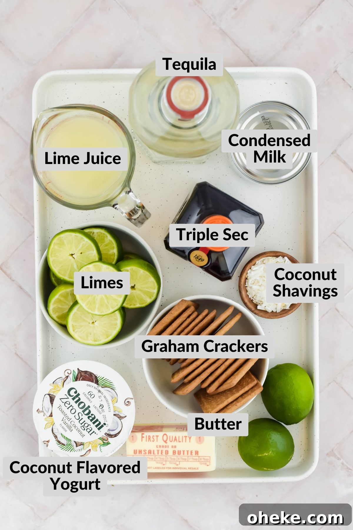 Tequila Lime Key Lime Pie Recipe with a Boozy Graham Cracker Crust 3 ingredients for tequila key lime pie on baking sheet on white background.