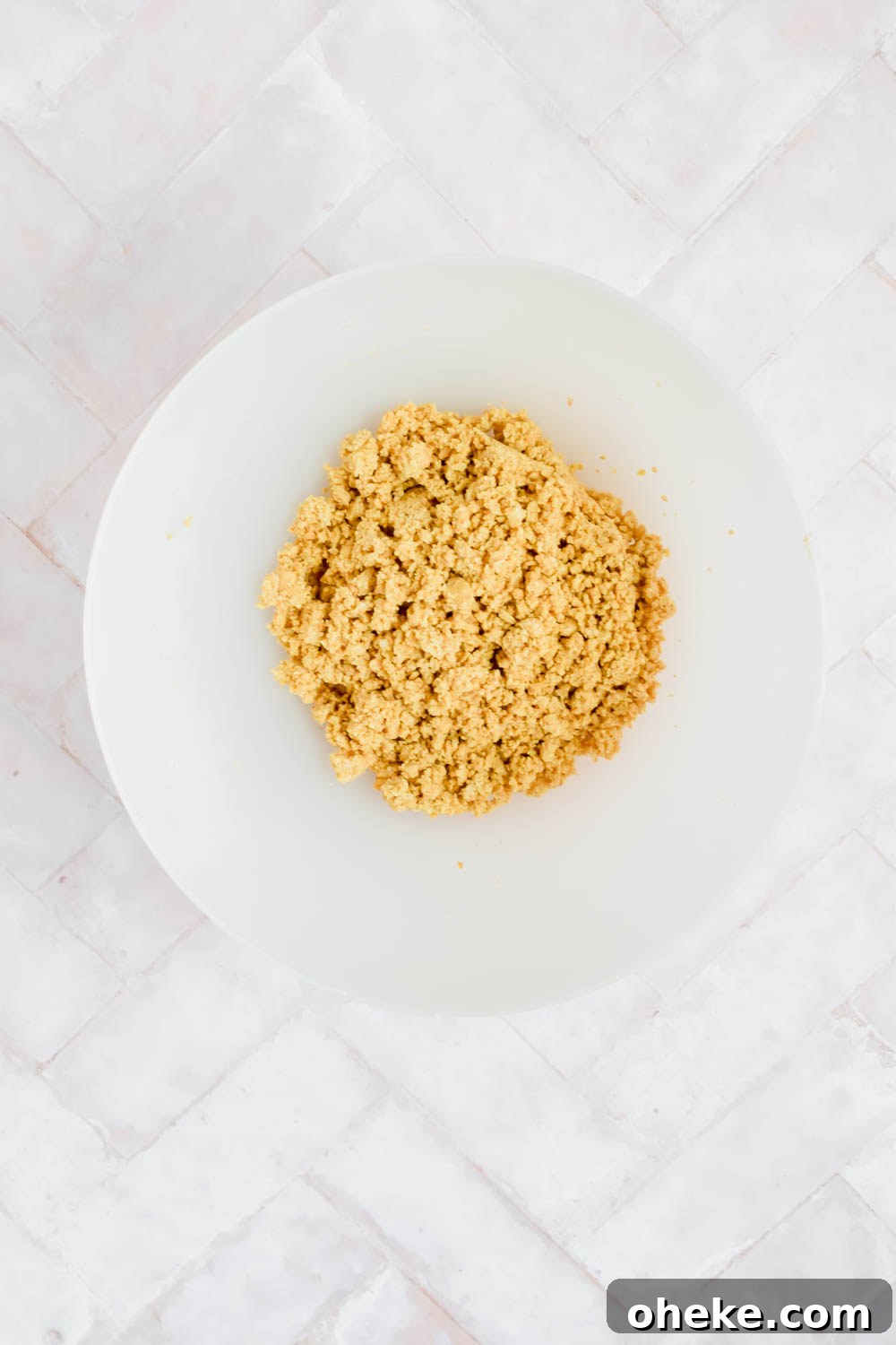 Tequila Lime Key Lime Pie Recipe with a Boozy Graham Cracker Crust 4 white bowl of crushed graham crackers for crust of chocolate coconut cream pie on white background.