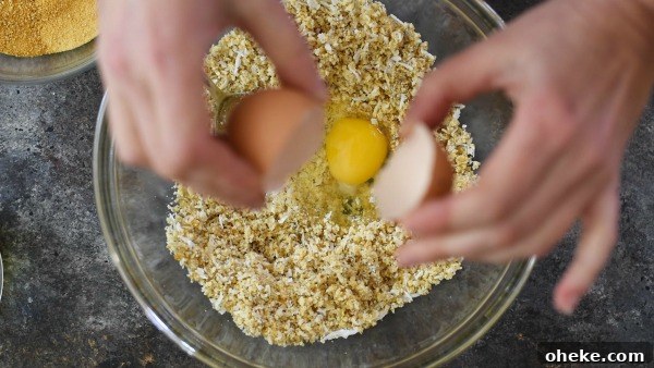 Paleo Lemon Bars with Almond-Coconut Crust Recipe 4 Breaking an egg into the crust ingredients.